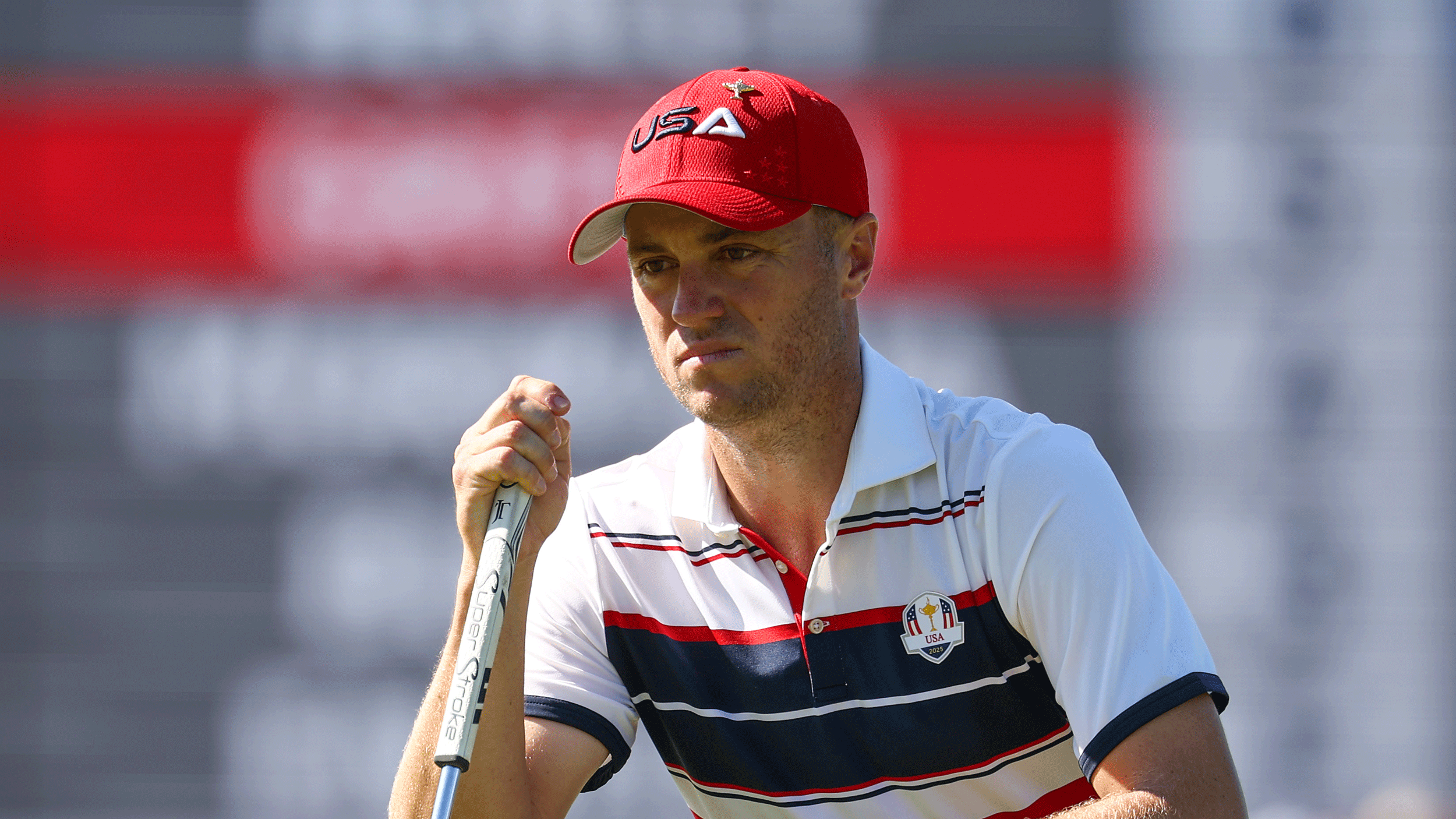 Justin Thomas crouches down behind a putt at the 2025 Ryder Cup